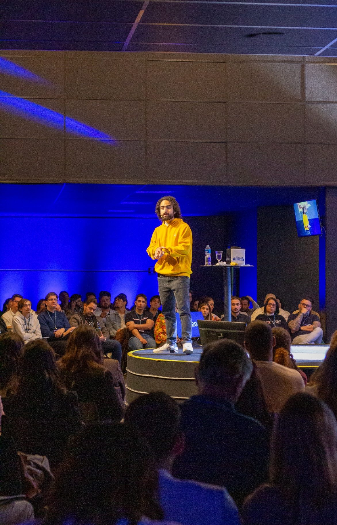 Euriler Jubé no palco, falando para uma plateia num evento presencial